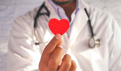 A doctor holding a paper heart
